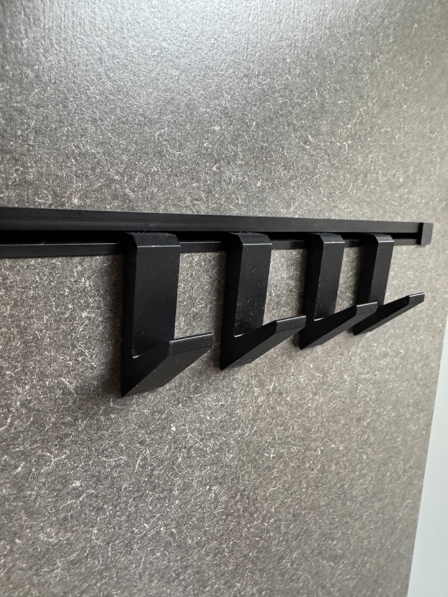 Hymer Hook-In multifunction rail system with black accessories fitted — showing the rectangular channel profile